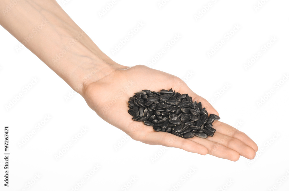 Nuts and meal preparation topic: human hand holding roasted sunflower seeds on a white isolated background in studio Nuts and meal preparation topic: human hand holding roasted sunflower seeds on a white isolated background in studio
