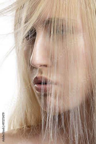 closeup portrait of beautiful model with blond hair covering he