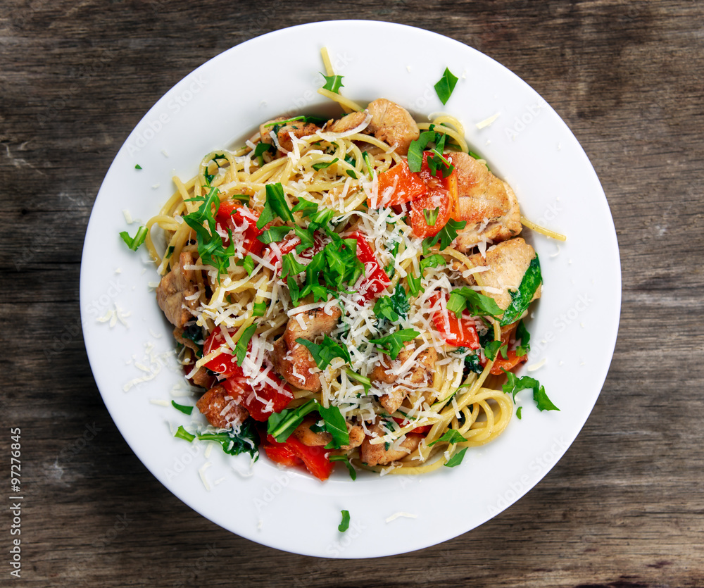 Italian Chicken Breast spaghetti with red pepper, Parmesan cheese and wild rocket lives. on old blue stone background Italian Chicken Breast spaghetti with red pepper, Parmesan cheese and wild rocket lives. on old blue stone background