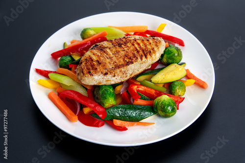 Grilled chicken fillet, breast with cooked vegetable  on plates.