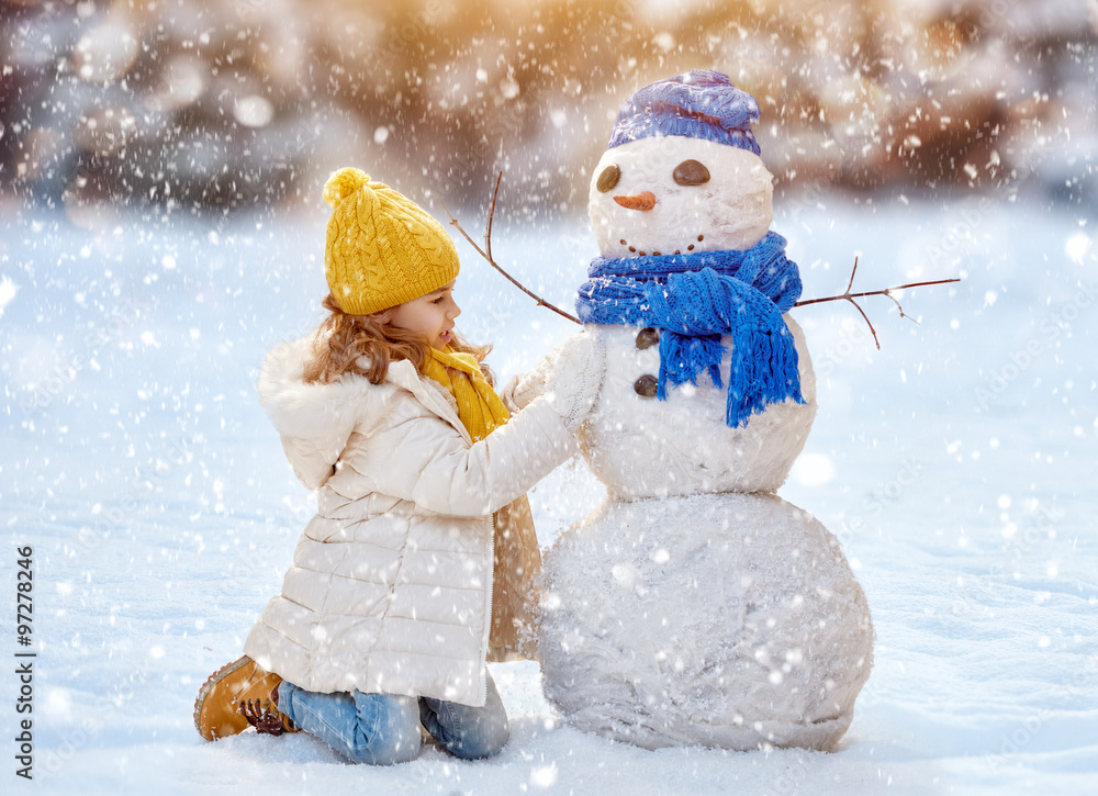 Naklejka premium girl playing with a snowman