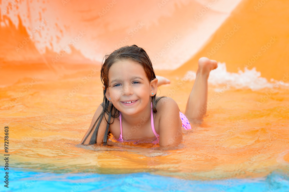 Adorable toddler girl on water slide at aquapark Adorable toddler girl on water slide at aquapark