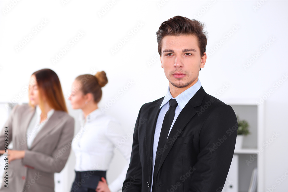Cheerful business man in office with colleagues in the background, sturt up team Cheerful business man in office with colleagues in the background, sturt up team