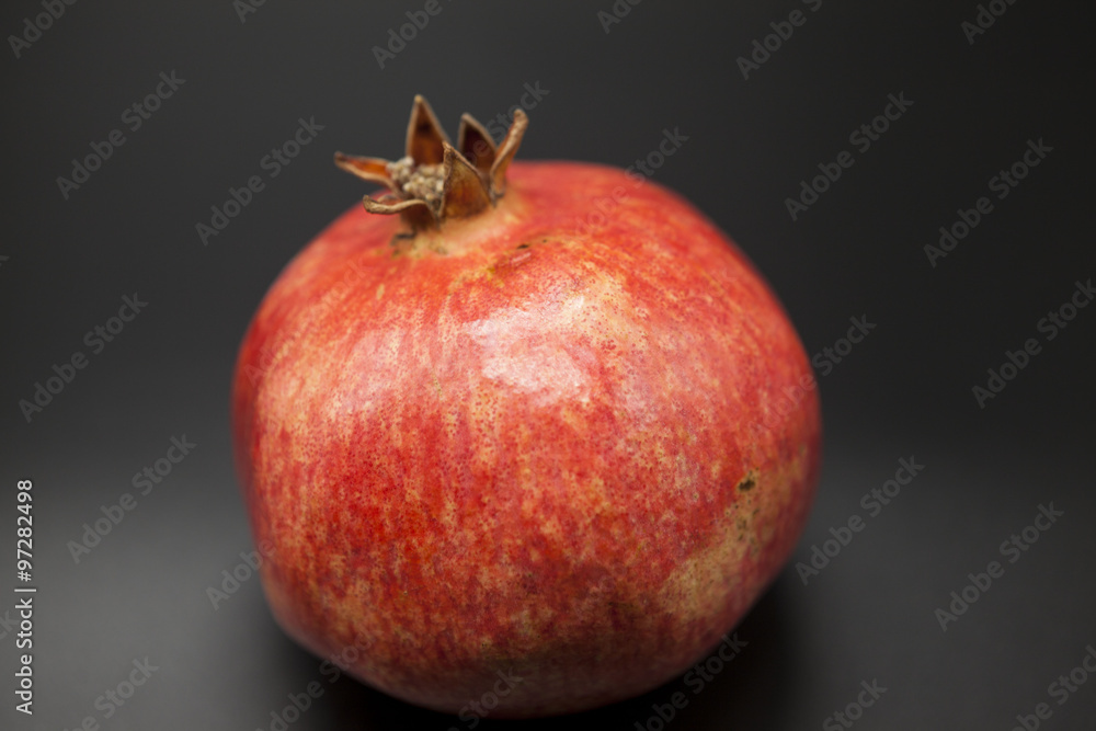 Spanish juicy ripe pomegranate closeup on a dark background Spanish juicy ripe pomegranate closeup on a dark background