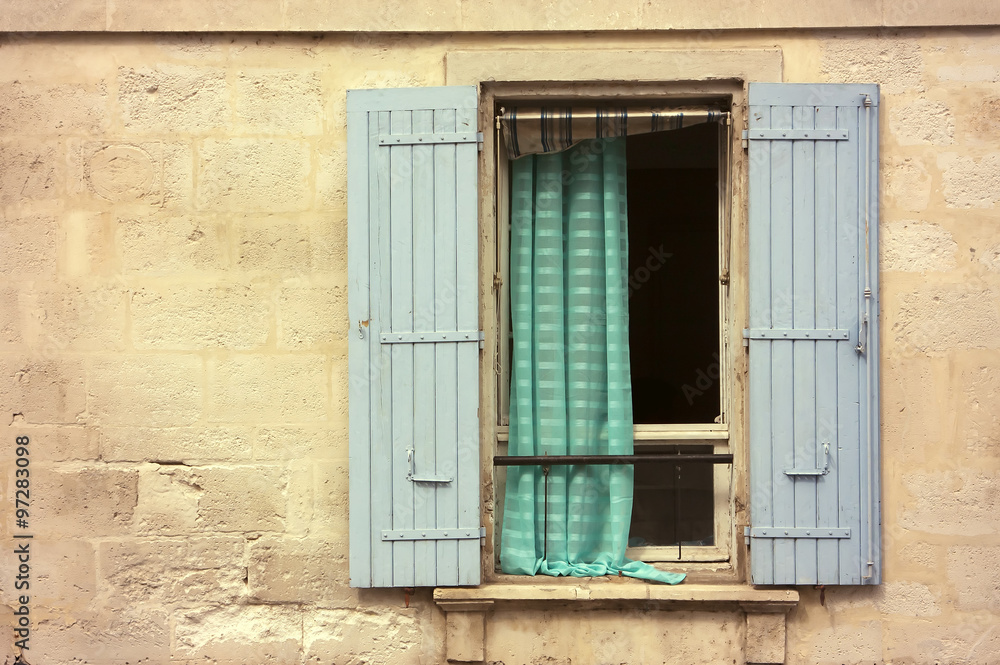 Opened wooden window with blue shutters