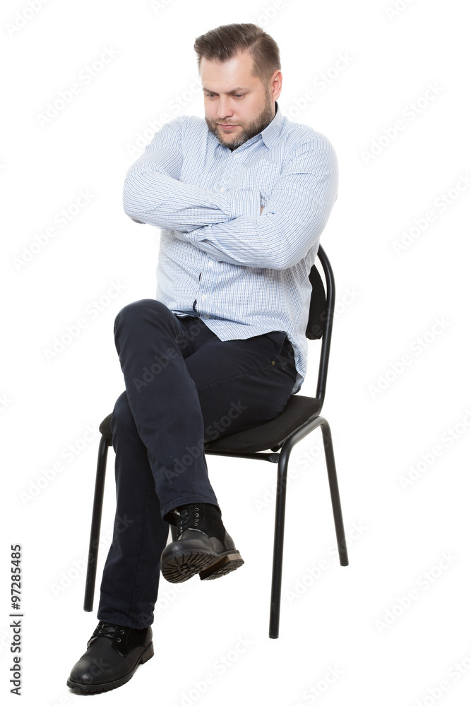 man sitting on chair. Isolated white background. Body language. gesture.  Training managers. sales agents. fully closed position. lowered eyes,  drawn-neck, arms and legs crossed Stock Photo | Adobe Stock