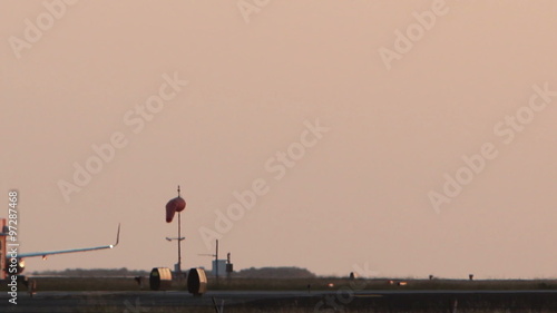 HD footage of a twin engine plane taking off in silhouette against an dusky orange sky.
