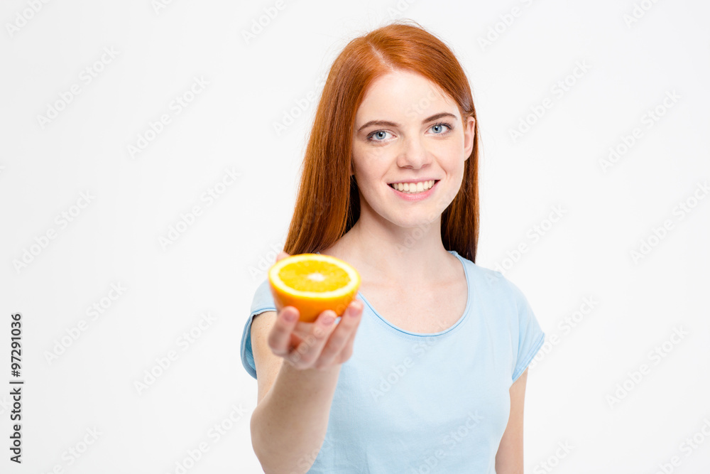 Beautiful woman with long red hair holding half of orange Beautiful woman with long red hair holding half of orange