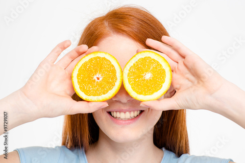 Happy redhead woman covering eyes with orange