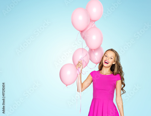 happy young woman with air balloons over blue