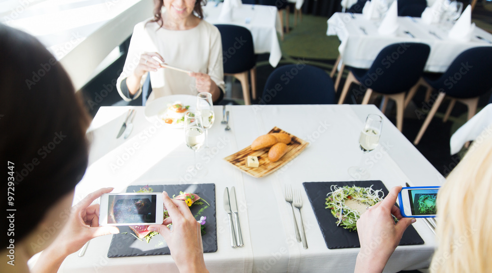 Obraz premium close up of women picturing food by smartphones