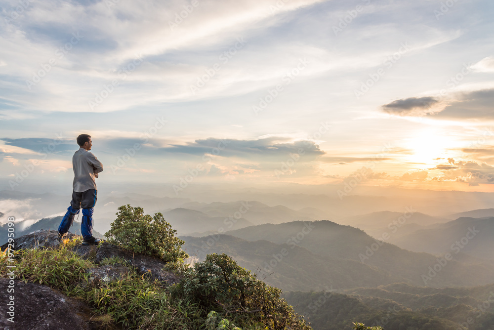 tourist man on top of a mountain enjoying valley view