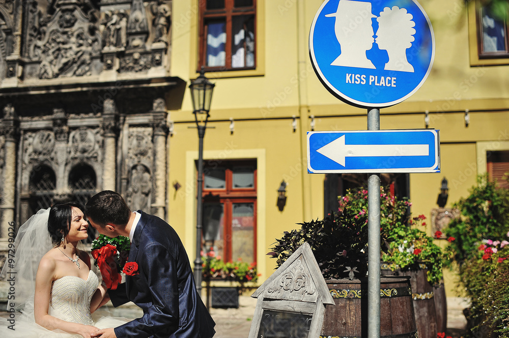 Wedding couple on streets of old city kissing on kiss place plat