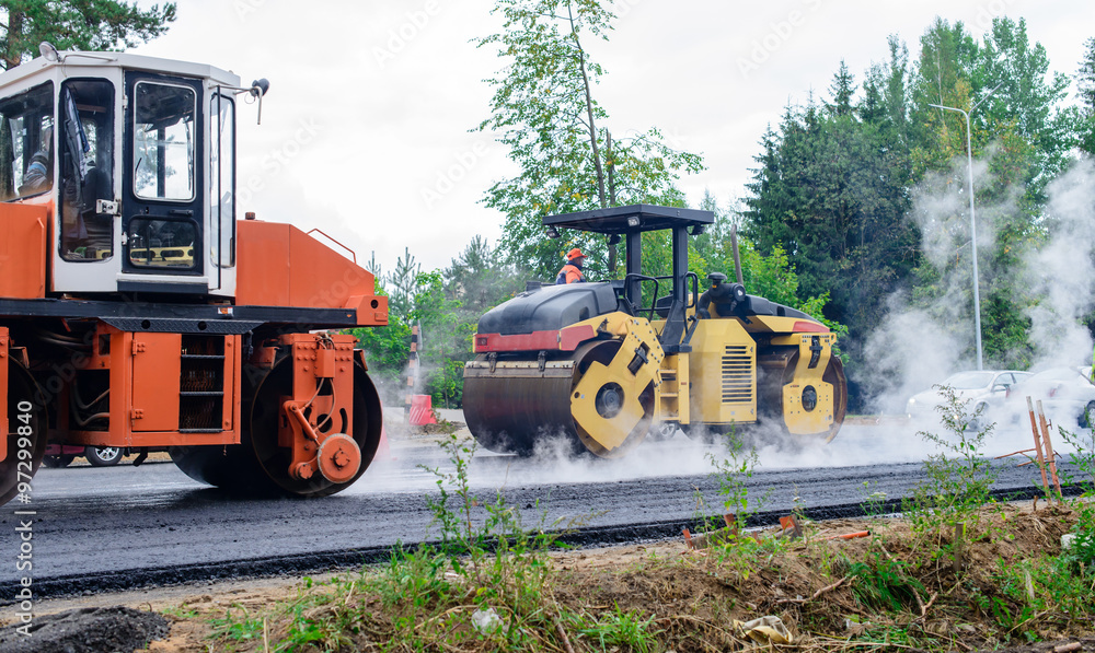 Road rollers building the new asphalt road, the process of layin