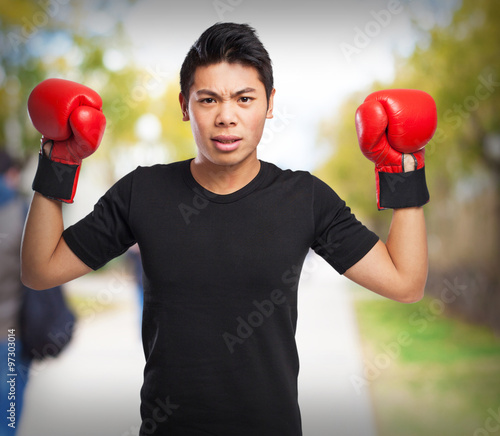 happy chinese sport man with boxing gloves © asierromero