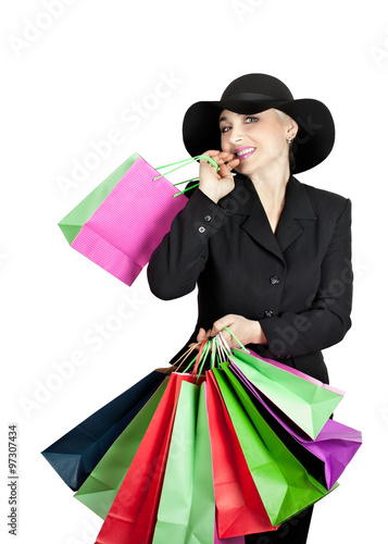 Happy lady in a business suit and hat with paper bags isolated on white background