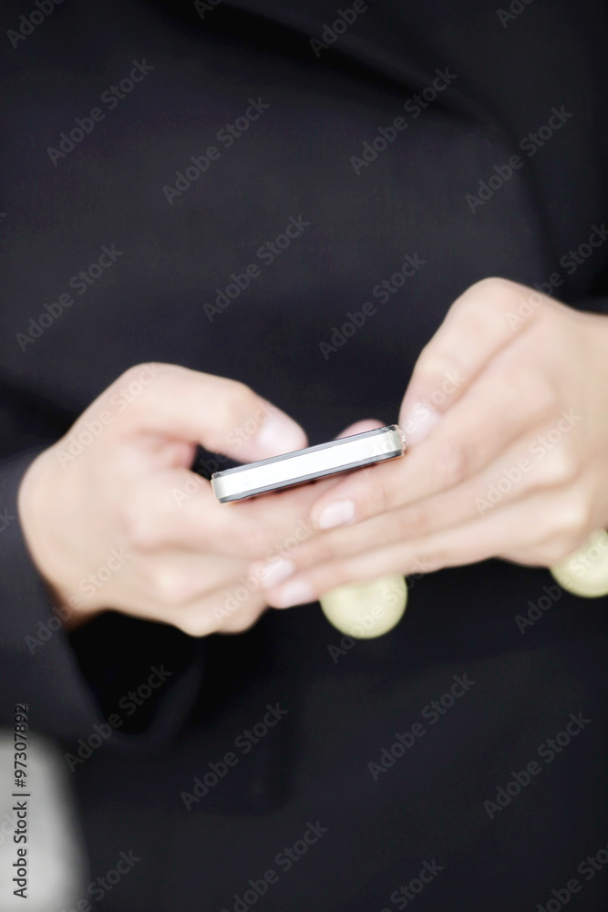 Hands of a woman texting on a mobile phone
