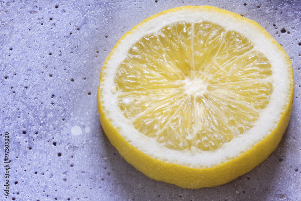 Slice of lemon citrus on blue texture background Slice of lemon citrus on blue texture background
