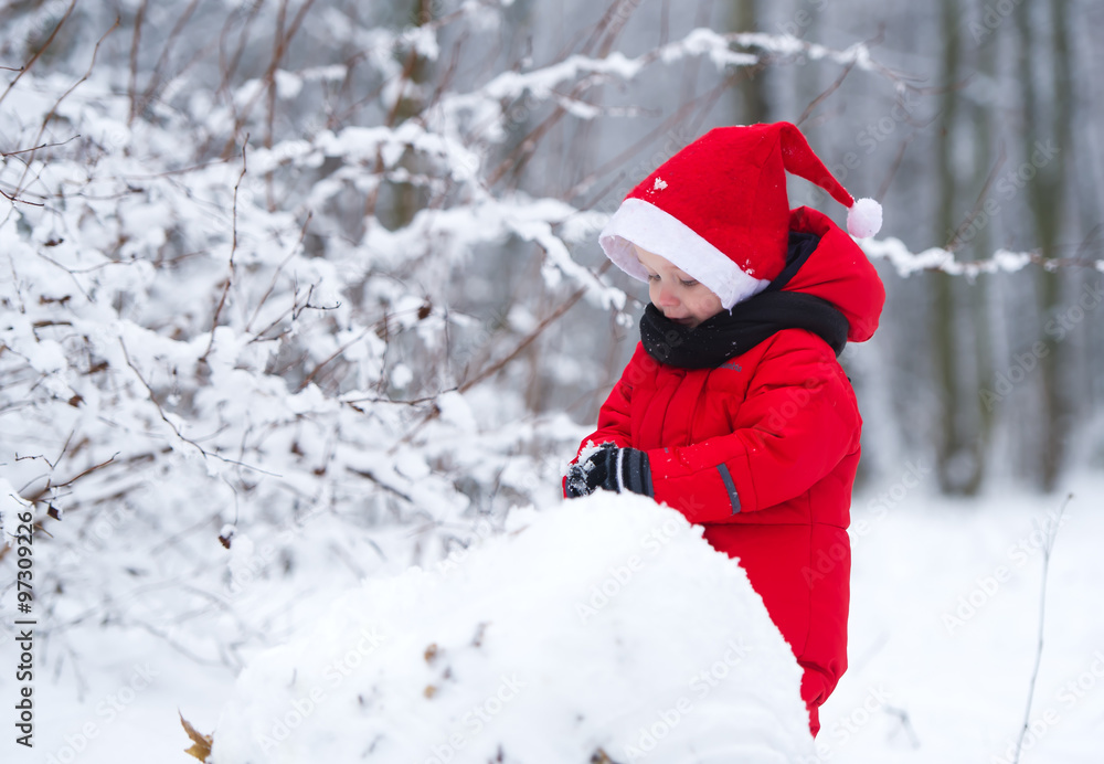 The kid builds a snowman from snow. The kid builds a snowman from snow.