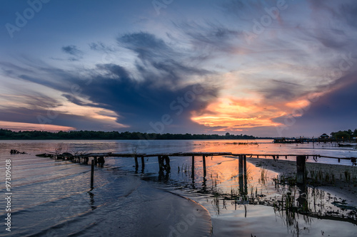 Wooden pier at sunset in the summer. Horizontal view of a wooden