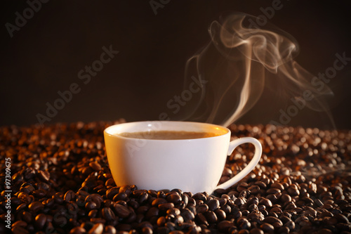 Cup of hot coffee and coffee beans closeup