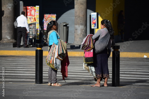 Dos jóvenes indígenas venden rebozos en la avenida Alcalde de Guadalajara.