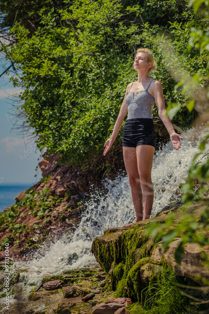Young Woman doing Yoga Position Near a Waterfall Young Woman doing Yoga Position Near a Waterfall