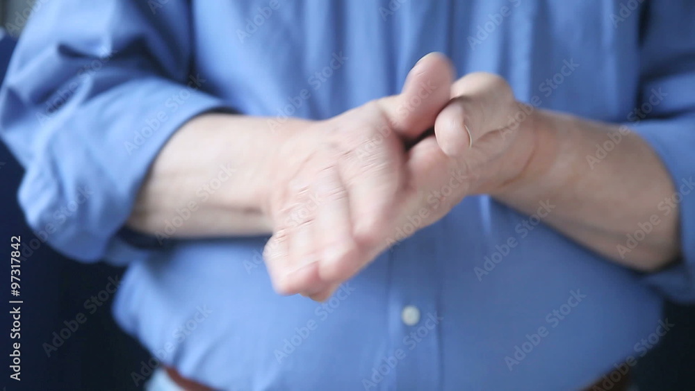 A man rubs his hands together. A man rubs his hands together.
