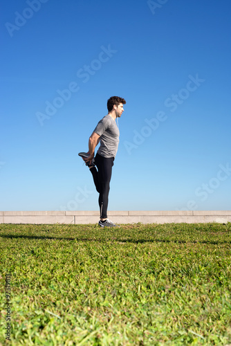 man stretches the leg before running space for text down photo