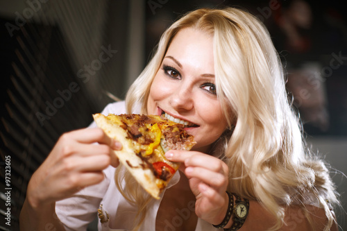 Attractive blond girl eating pizza
