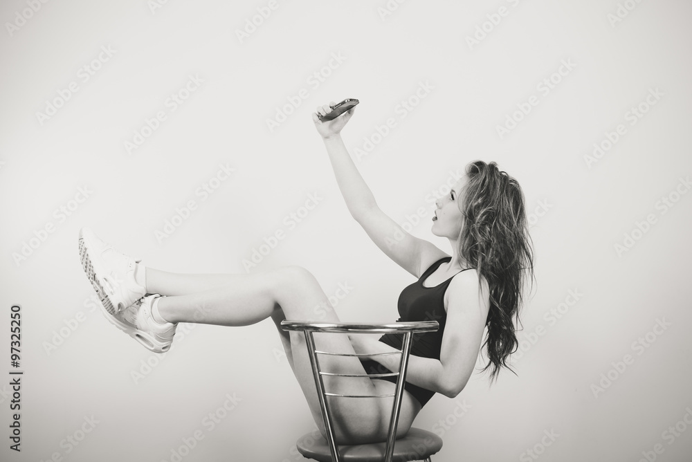 Beautiful young woman in black jumpsuit sitting and making selfie Stock  Photo | Adobe Stock