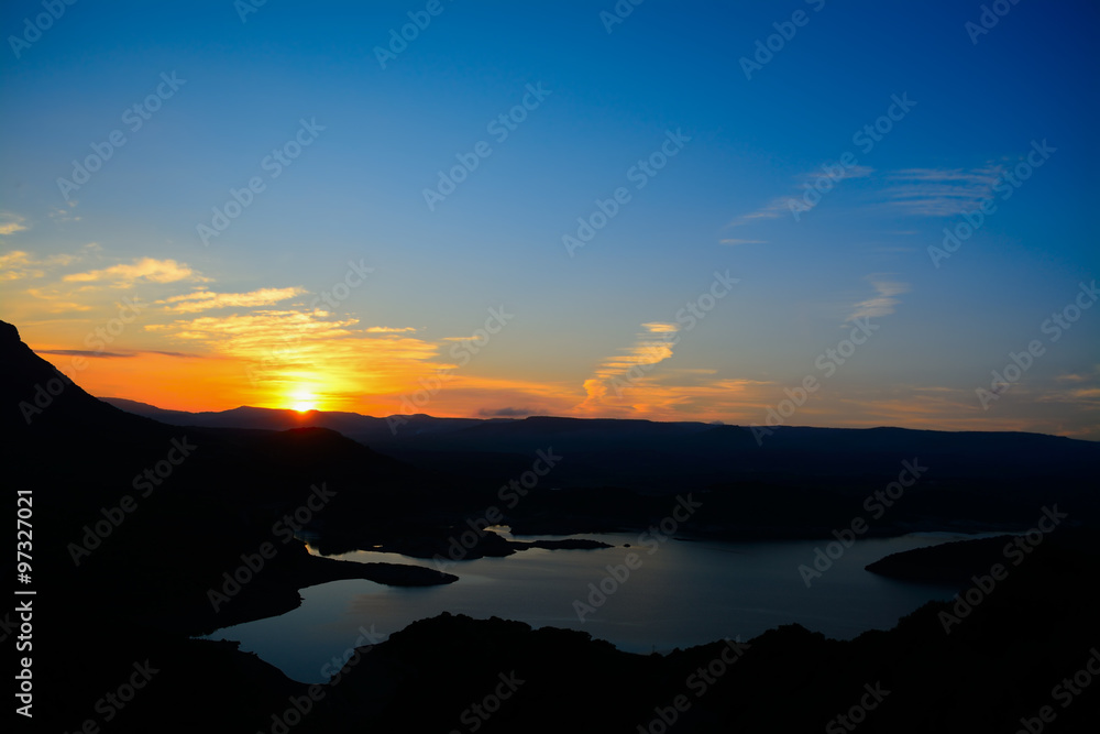 Fototapeta premium lake and hills under a colorful sky at sunset