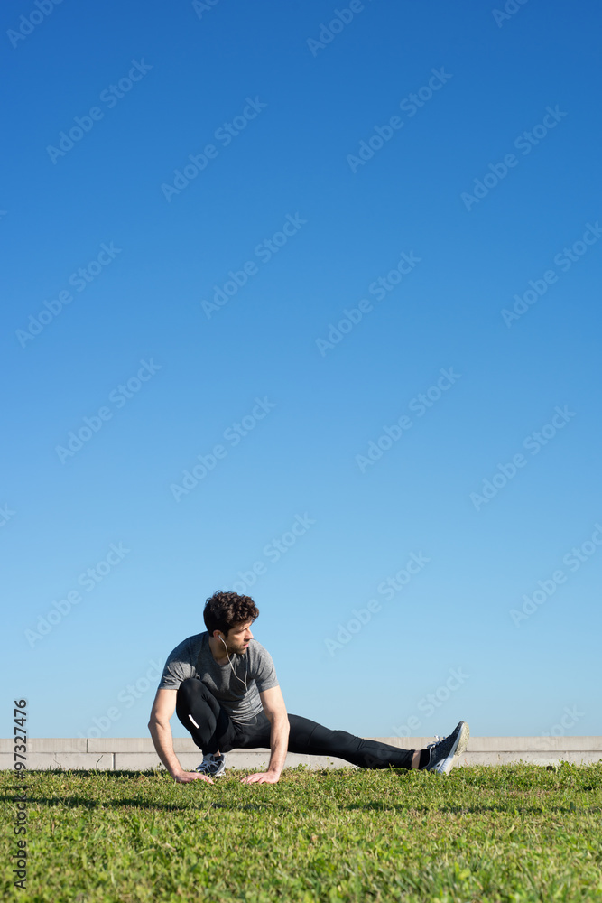 man stretches the leg in the ground space for text up