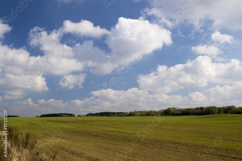 Clouds over a green field