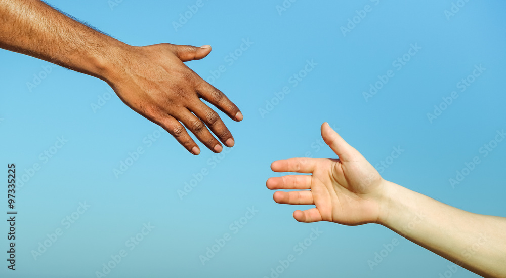 Black hand man helping white person - Different skin color hands united against racism and racial problem - Concept of humane aid between different cultures and religion - friendship between peoples
