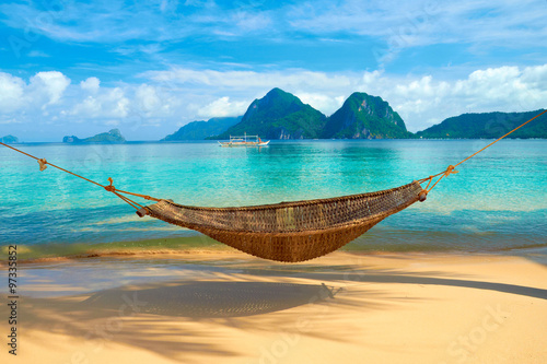 A hammock at the beach with the view of Bacuit Archipelago islands (El Nido, Philippines