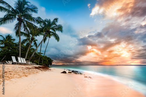 Exotic long exposure seascape with palm trees at sunset, on a public beach in Cayo Levantado, Dominican Republic photo