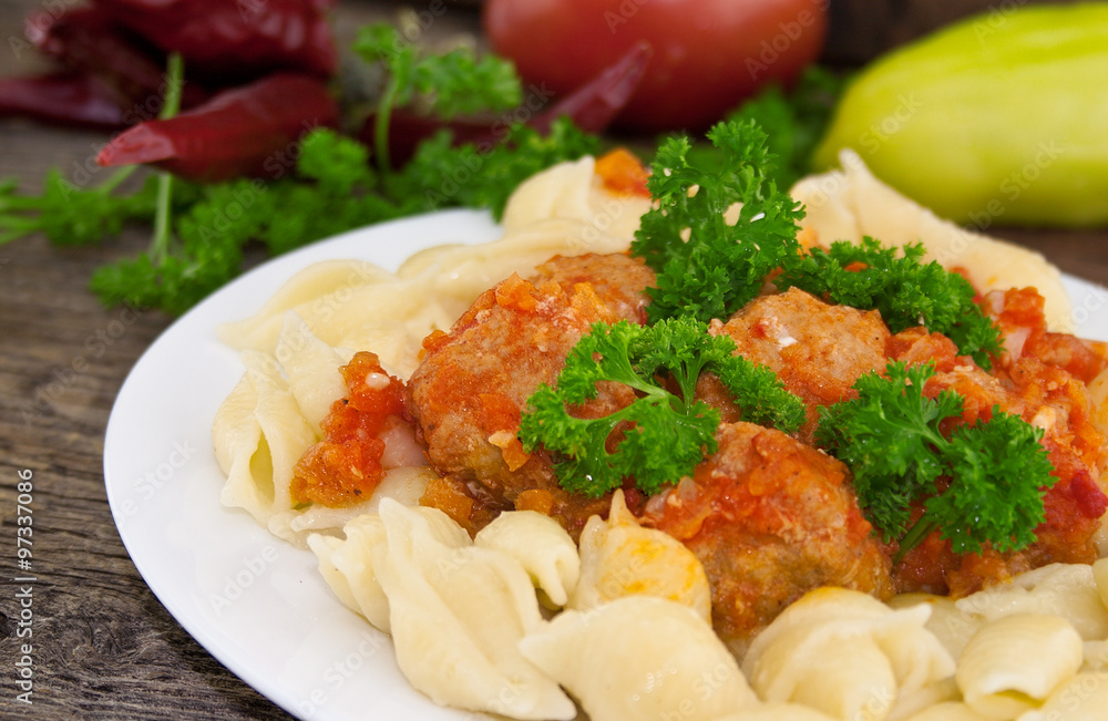 Pasta Conchiglie and meatballs with tomato sauce on rustic woode Pasta Conchiglie and meatballs with tomato sauce on rustic woode