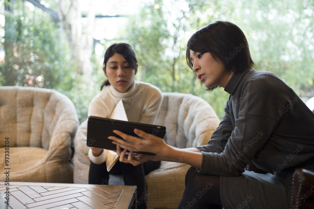 Fototapeta premium Women are talking while showing a tablet