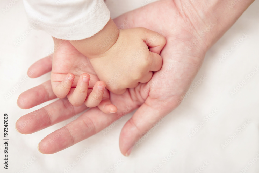 Baby hand gently holding adult's finger (Soft focus and blurry) Baby hand gently holding adult's finger (Soft focus and blurry)