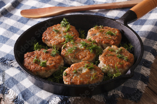 Принти на полотні fishcakes with herbs close-up in a pan. Horizontal