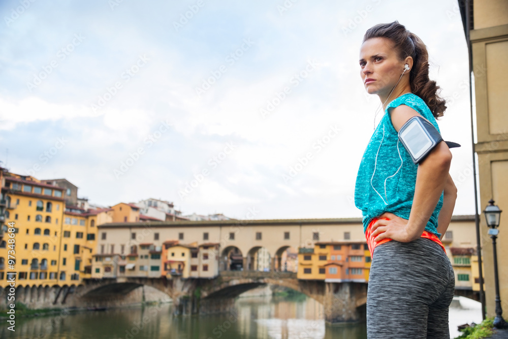 Fitness woman in sportswear staying next to Ponte Vecchio bridge