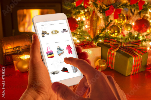 Christmas online shopping with phone. Christmas tree, gifts, lights and decorations. 