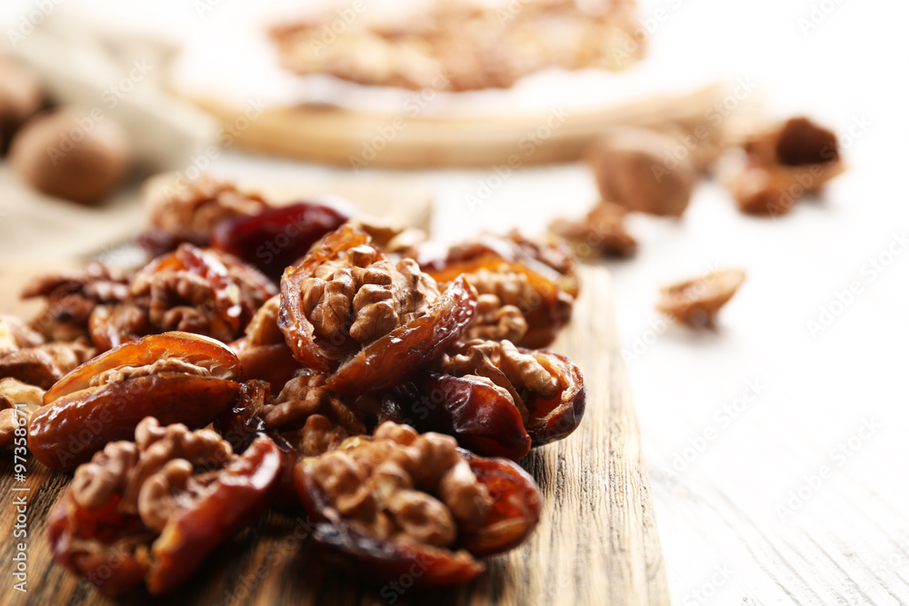Walnut in date fruit on cutting board, close-up Walnut in date fruit on cutting board, close-up