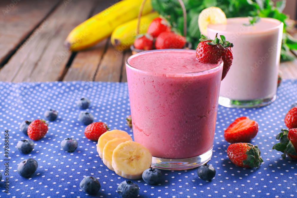 Glasses of fresh cold smoothie with fruit and berries, on blue tablecloth background Glasses of fresh cold smoothie with fruit and berries, on blue tablecloth background