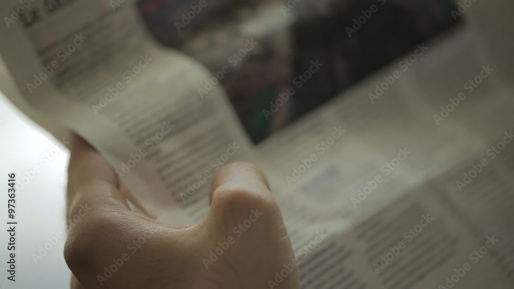 close-up, modern man reading a French newspaper in the morning in his new office