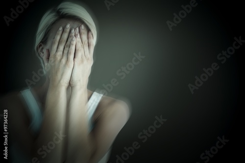 Composite image of sad blonde woman with head on hands 
