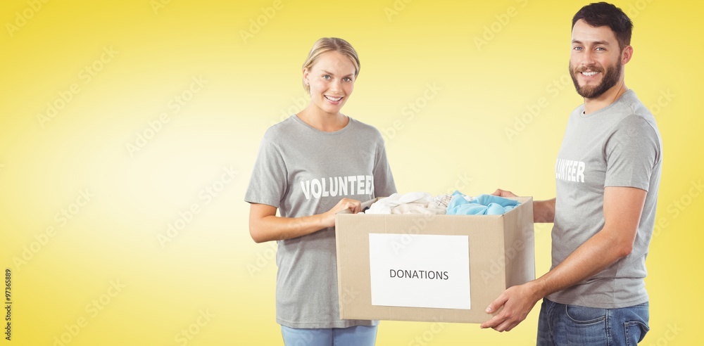 Smiling volunteers holding clothes donation box Smiling volunteers holding clothes donation box