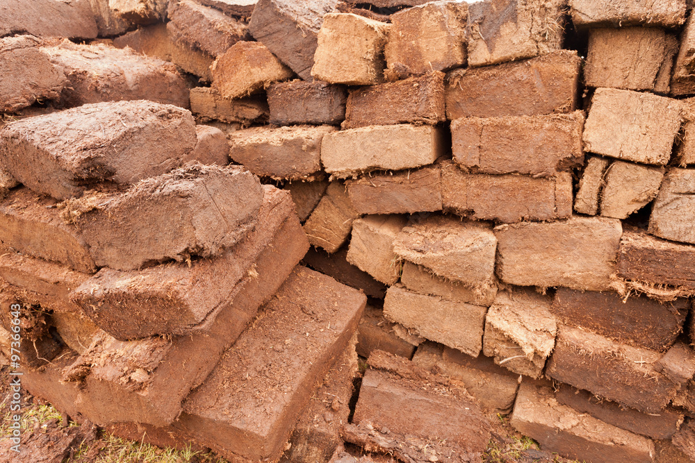 Obraz premium Stacked peat turf briquette cuttings background pattern