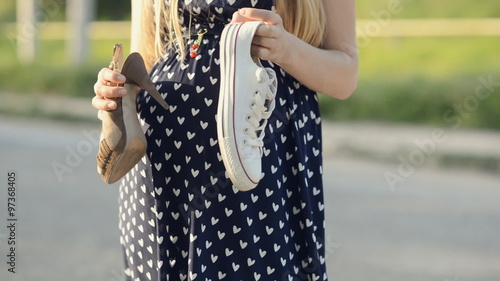 Pregnant woman chooses shoes for walking photo